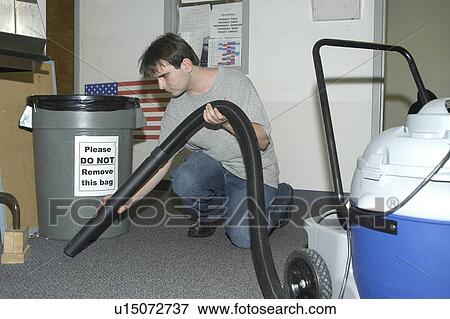 A man with a disability is working is in an office vacuuming the floor. View Large Photo Image Stock Photo - A man with a disability is working is in an office vacuuming the floor.. Fotosearch