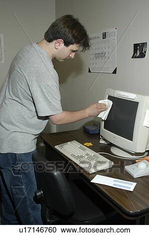 A man with a disability working in an office cleaning the computer. View Large Photo Image Stock Image - A man with a disability working in an office cleaning the computer.. Fotosearch
