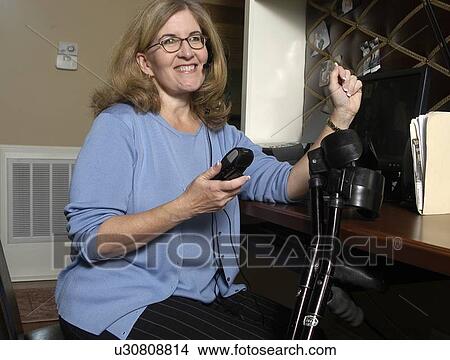 Picture - Busy woman talks on the phone.. Fotosearch