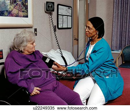 Elderly woman with disabilities during a routine Doctor's visit having her blood pressure checked by the nurse. View Large Photo Image Stock Photography - Elderly woman with disabilities during a routine Doctor's visit having her blood pressure checked by the nurse.. Fotosearch
