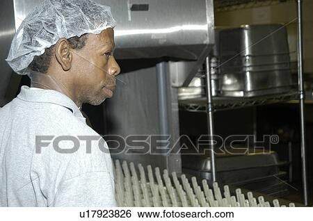 Stock Photograph - Man with disabilities in a commercial kitchen washing dishes.. Fotosearch