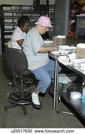 Stock Image - Person with a disability working in a commercial kitchen.. Fotosearch