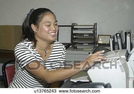 Stock Image - Woman with a disability sending a fax.. Fotosearch