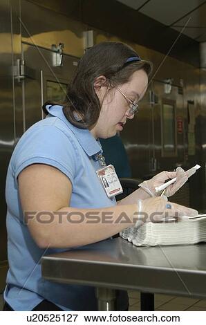 Woman with DownÆs Syndrome working in the food service industry. View Large Photo Image Stock Photo - Woman with DownÆs Syndrome working in the food service industry.. Fotosearch