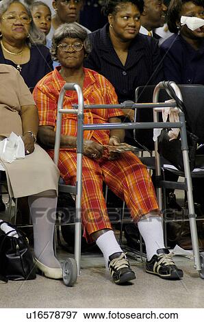 Elderly African American woman sitting in the bleachers of an auditorium, participating in a group event with her walker positioned in front of her for support. View Large Photo Image Stock Photo - Elderly African American woman sitting in the bleachers of an auditorium, participating in a group event with her walker positioned in front of her for support.. Fotosearch