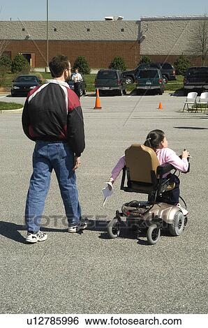 Husband and wife (wheelchair user) heading toward a community center View Large Photo Image Stock Photograph - Husband and wife (wheelchair user) heading toward a community center. Fotosearch