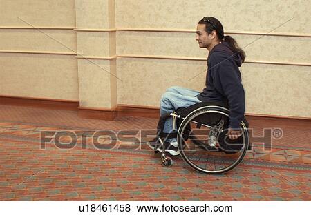 Stock Photo - Man with a disability rushing to the next session at a Disability Activists Conference.. Fotosearch