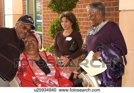 Stock Image - People with disabilities laughing, hugging and chatting after participating in a Disability Activists Conference.. Fotosearch