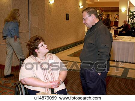 Person with a disability, utilizing a wheelchair for mobility, talking with a presenter during a conference/meeting break. View Large Photo Image Stock Photo - Person with a disability, utilizing a wheelchair for mobility, talking with a presenter during a conference/meeting break.. Fotosearch