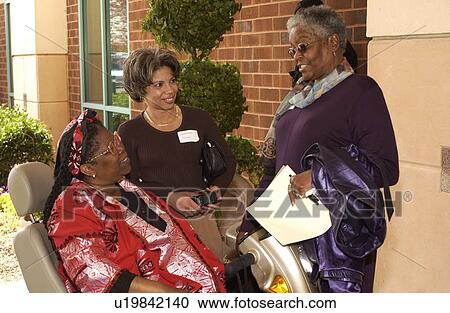 Three women chatting and laughing as they reflect upon their day at a Disability Activists Conference. View Large Photo Image Stock Image - Three women chatting and laughing as they reflect upon their day at a Disability Activists Conference.. Fotosearch