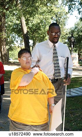 Two community leaders, a woman with mental retardation providing assistance to a man who is blind and has mental retardation. View Large Photo Image Stock Image - Two community leaders, a woman with mental retardation providing assistance to a man who is blind and has mental retardation.. Fotosearch
