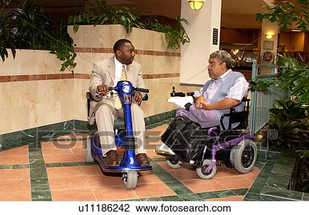 Stock Image - Two men talking during a break at a Disability Activist Conference.. Fotosearch