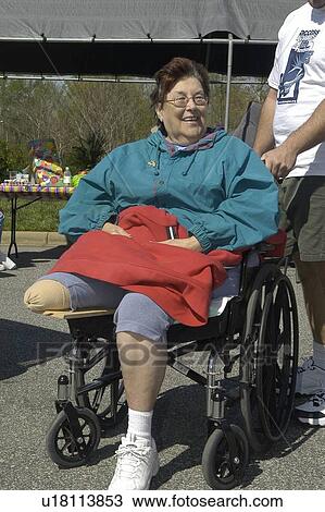 Woman in a wheelchair (single amputee) tours a community fair View Large Photo Image Stock Image - Woman in a wheelchair (single amputee) tours a community fair. Fotosearch