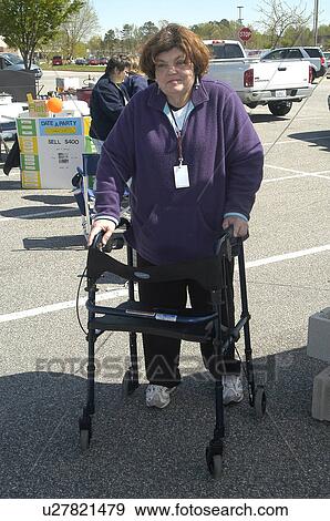 Woman using a walker at a community event View Large Photo Image Stock Photo - Woman using a walker at a community event. Fotosearch