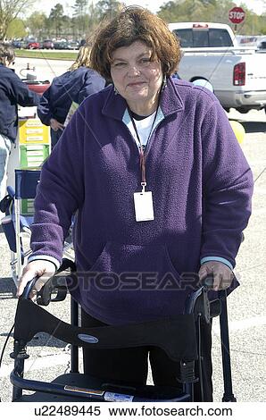 Stock Photography - Woman using a walker poses for the camera at a community fair. Fotosearch