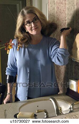 A woman is brushing her hair. View Large Photo Image Stock Photo - A woman is brushing her hair.. Fotosearch