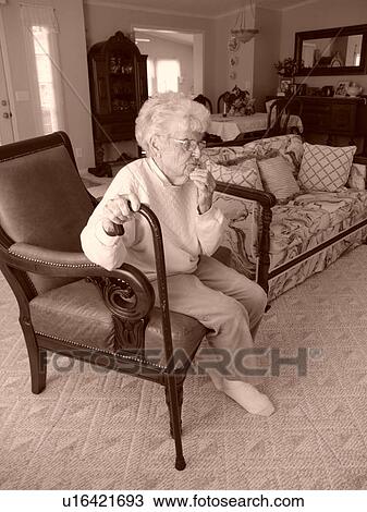 An elderly woman has quiet time in her living room. View Large Photo Image Stock Image - An elderly woman has quiet time in her living room.. Fotosearch