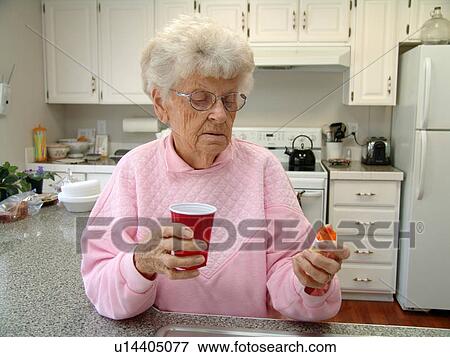 An elderly woman takes her daily prescriptions. View Large Photo Image Stock Photo - An elderly woman takes her daily prescriptions.. Fotosearch