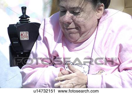Stock Image - Close shot of woman seated in a power wheelchair. Fotosearch