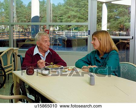 Elderly man with a disability having lunch with one of his therapists. View Large Photo Image Stock Image - Elderly man with a disability having lunch with one of his therapists.. Fotosearch