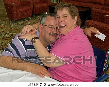 Man and woman both with a developmental disability smiling as they embrace each other. View Large Photo Image Stock Image - Man and woman both with a developmental disability smiling as they embrace each other.. Fotosearch