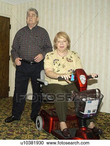 Woman with a disability, utilizing a scooter for mobility assistance, entering a conference room with her husband. View Large Photo Image Stock Image - Woman with a disability, utilizing a scooter for mobility assistance, entering a conference room with her husband.. Fotosearch