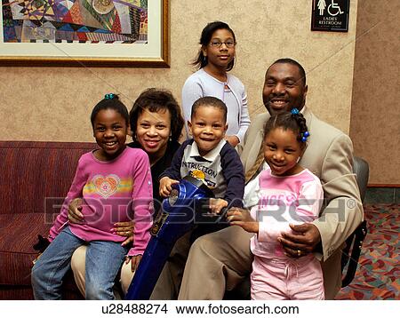 Happy family posing for a picture while spending time together relaxing at a hotel -- Dad has a disability and utilizes a wheelchair for mobility. View Large Photo Image Picture - Happy family posing for a picture while spending time together relaxing at a hotel -- Dad has a disability and utilizes a wheelchair for mobility.. Fotosearch