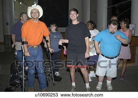 Stock Image - Individuals with a variety of disabilities in a lobby area.. Fotosearch