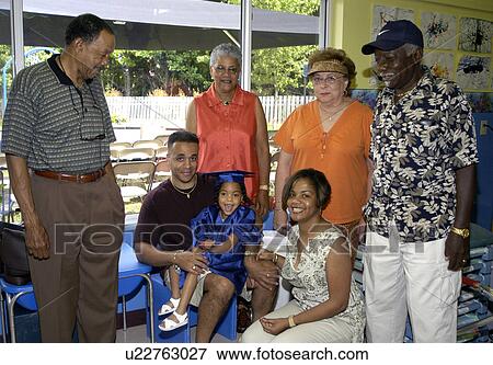 Stock Photo - Little girl with multiple disabilities thrilled to have her family and extended family attending her pre-school graduation.. Fotosearch