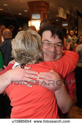 Man and woman both with developmental disabilities smiling as they embrace each other. View Large Photo Image Picture - Man and woman both with developmental disabilities smiling as they embrace each other. . Fotosearch