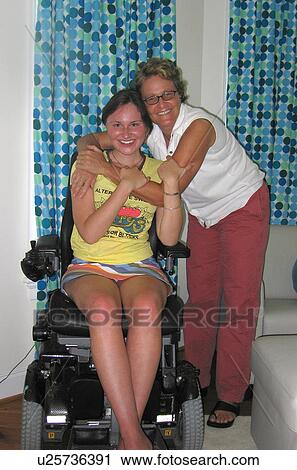Stock Image - Mother and daughter (wheelchair user) share a smile for the camera.. Fotosearch