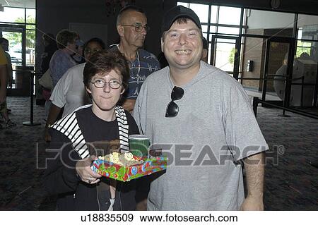 Two people with disabilities at the theatre û preparing to watch a movie with their soft drink and popcorn in hand. View Large Photo Image Stock Photo - Two people with disabilities at the theatre û preparing to watch a movie with their soft drink and popcorn in hand.. Fotosearch