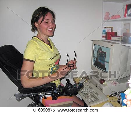 Woman (elevating wheelchair user) holding glasses takes a break at her computer workstation. View Large Photo Image Stock Photography - Woman (elevating wheelchair user) holding glasses takes a break at her computer workstation.. Fotosearch
