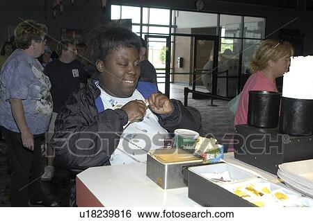 Woman with disabilities at the theatre û preparing to watch a movie with her soft drink and popcorn. View Large Photo Image Stock Photograph - Woman with disabilities at the theatre û preparing to watch a movie with her soft drink and popcorn.. Fotosearch
