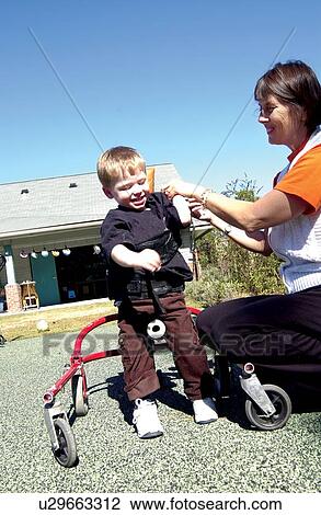 Adorable little boy with a disability learning to use a walker to make his way around the playground at school. View Large Photo Image Stock Image - Adorable little boy with a disability learning to use a walker to make his way around the playground at school.. Fotosearch