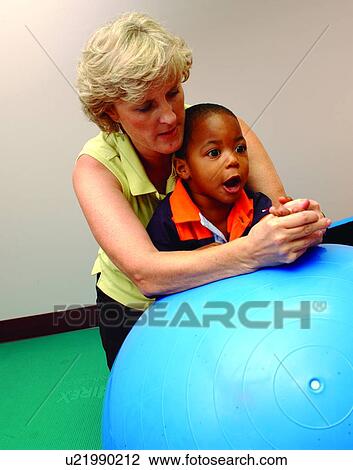 Adorable little boy with multiple disabilities leaning against a large therapy ball during a session with his physical therapist. View Large Photo Image Stock Image - Adorable little boy with multiple disabilities leaning against a large therapy ball during a session with his physical therapist.. Fotosearch