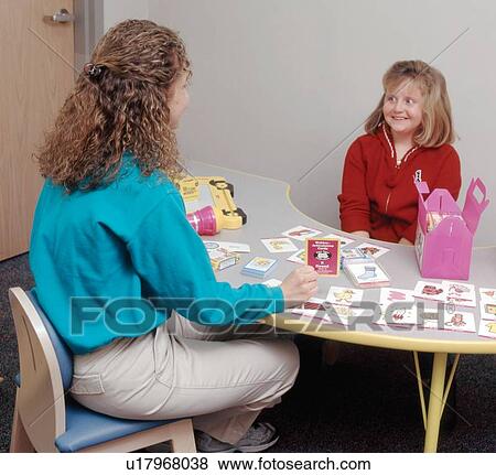Cute young girl with a disability with her therapist during a speech therapy session. View Large Photo Image Stock Photo - Cute young girl with a disability with her therapist during a speech therapy session.. Fotosearch