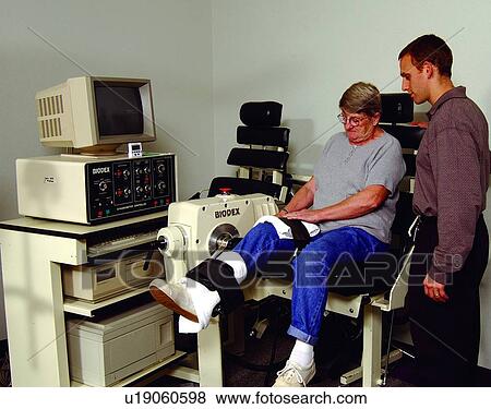 Elderly woman utilizing a physical therapy machine under the observation of her physical therapist. View Large Photo Image Stock Photo - Elderly woman utilizing a physical therapy machine under the observation of her physical therapist.. Fotosearch