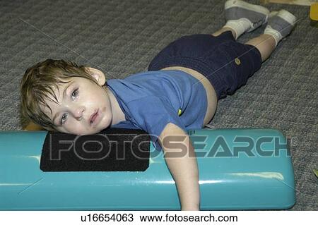 Stock Image - Image of a child with multiple disabilities during a physical therapy session.. Fotosearch