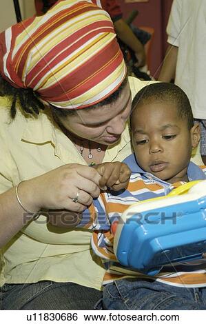 Little boy with severe physical disabilities playing with a toy with the assistance of a care provider. View Large Photo Image Stock Photograph - Little boy with severe physical disabilities playing with a toy with the assistance of a care provider.. Fotosearch