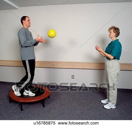 Man with a disability utilizing various techniques to improve or maintain his skills during a session with his physical therapist. View Large Photo Image Stock Photography - Man with a disability utilizing various techniques to improve or maintain his skills during a session with his physical therapist.. Fotosearch