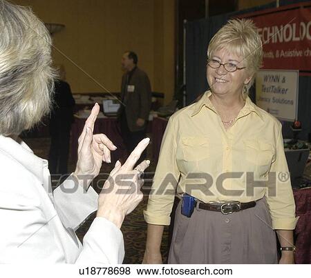Two women with hearing impairments/deafness conversing via American Sign Language. View Large Photo Image Stock Photo - Two women with hearing impairments/deafness conversing via American Sign Language.. Fotosearch