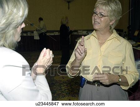 Two women with hearing impairments/deafness conversing via American Sign Language. View Large Photo Image Stock Photo - Two women with hearing impairments/deafness conversing via American Sign Language.. Fotosearch