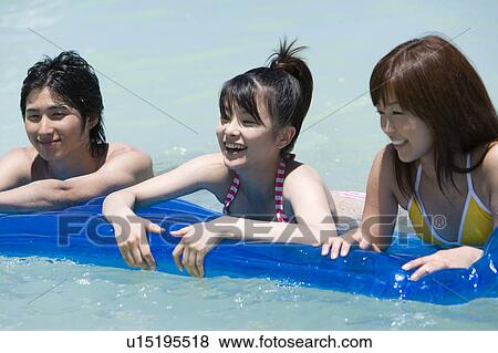 Young people on a pool raft in the sea, Saipan, USA View Large Photo Image Stock Photo - Young people on a pool raft in the sea, Saipan, USA . Fotosearch