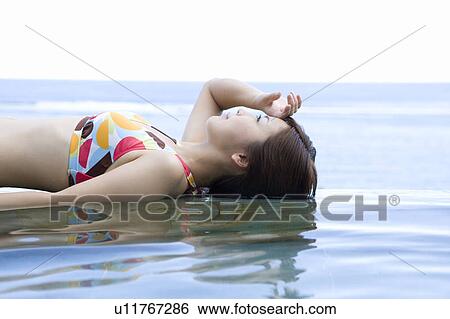 Young woman in a bikini lying on water, Saipan View Large Photo Image Stock Photograph - Young woman in a bikini lying on water, Saipan. Fotosearch