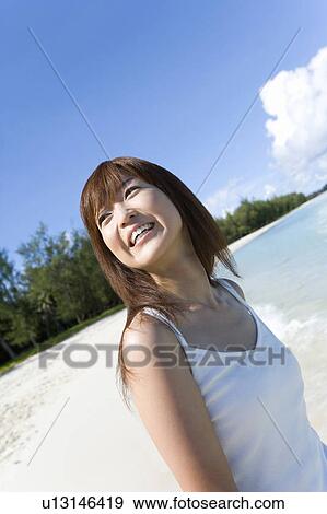 Stock Photo - Young woman smiling on beach, Saipan, USA . Fotosearch