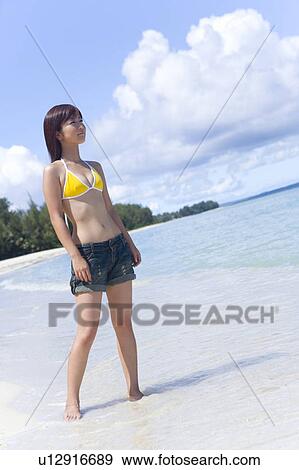 Young woman standing on beach, smiling, Saipan, USA View Large Photo Image Stock Photo - Young woman standing on beach, smiling, Saipan, USA . Fotosearch