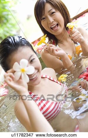 Young women in a bath full of flowers, Saipan, Focus on Background View Large Photo Image Stock Photo - Young women in a bath full of flowers, Saipan, Focus on Background. Fotosearch