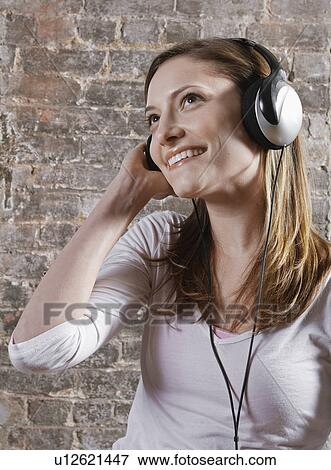Mid-Adult woman Listening to Headphones View Large Photo Image Stock Photo - Mid-Adult woman Listening to Headphones. Fotosearch