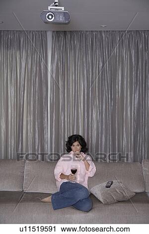 Mid adult woman with red wine watching TV View Large Photo Image Stock Image - Mid adult woman with red wine watching TV. Fotosearch